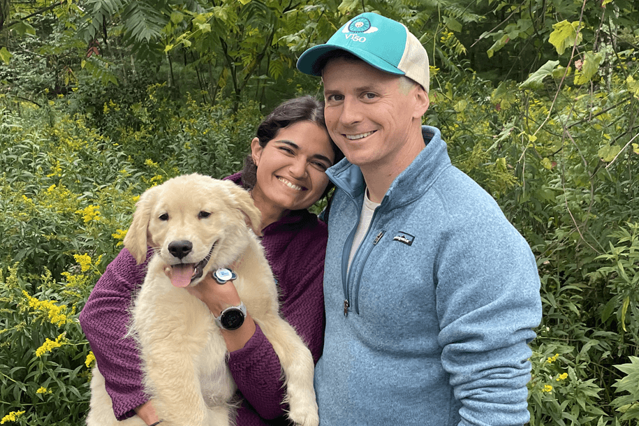 a smiling woman and man with a dog