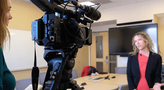 a woman films another woman for a TV interview