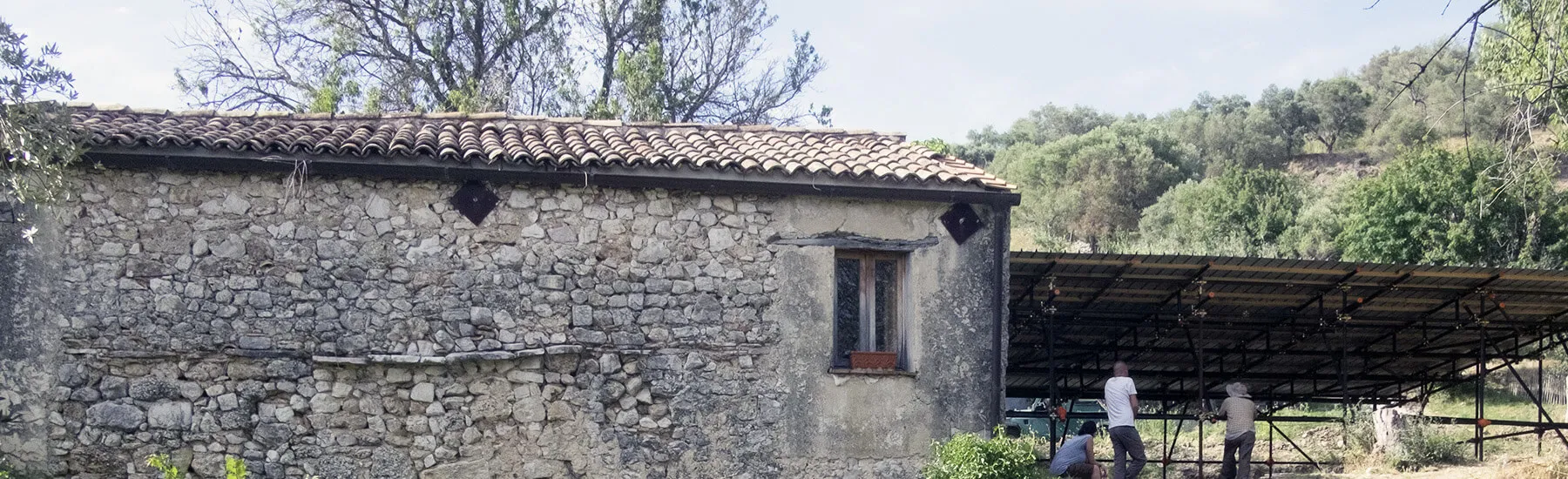 A stone building featuring a sloped roof and a rustic wooden door