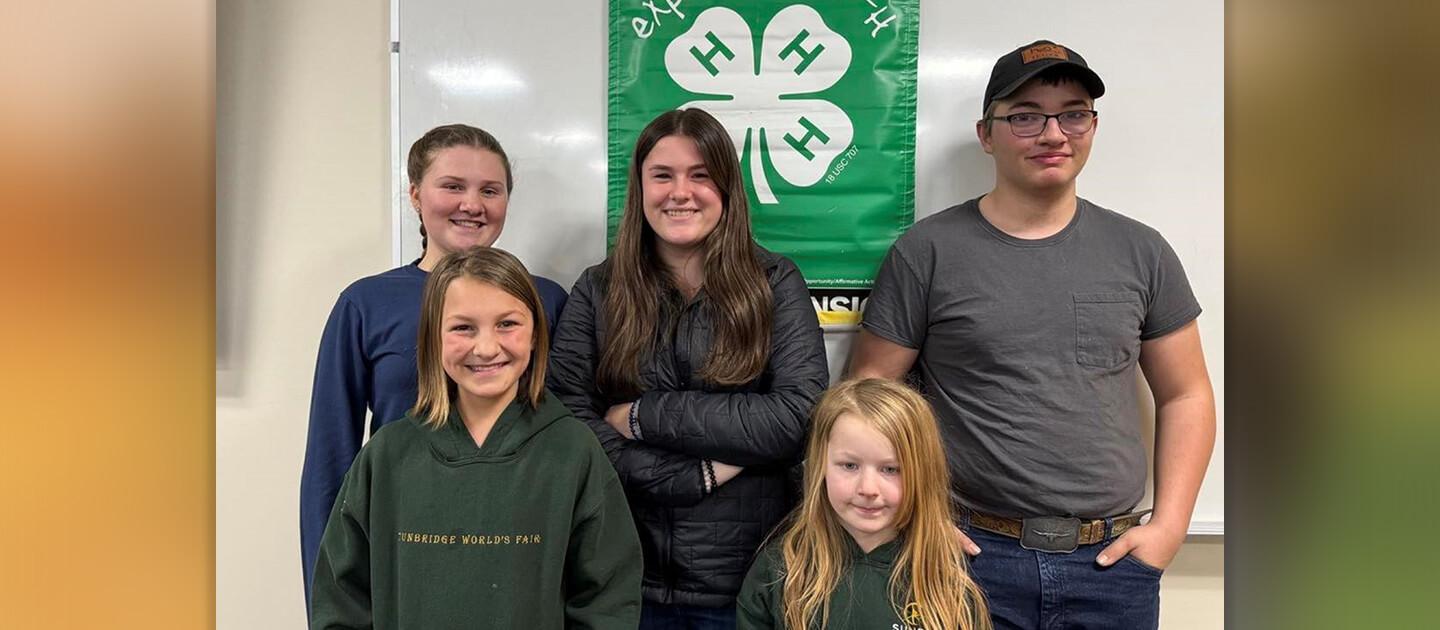 5 4-h teamsters posing in front of a 4-h banner