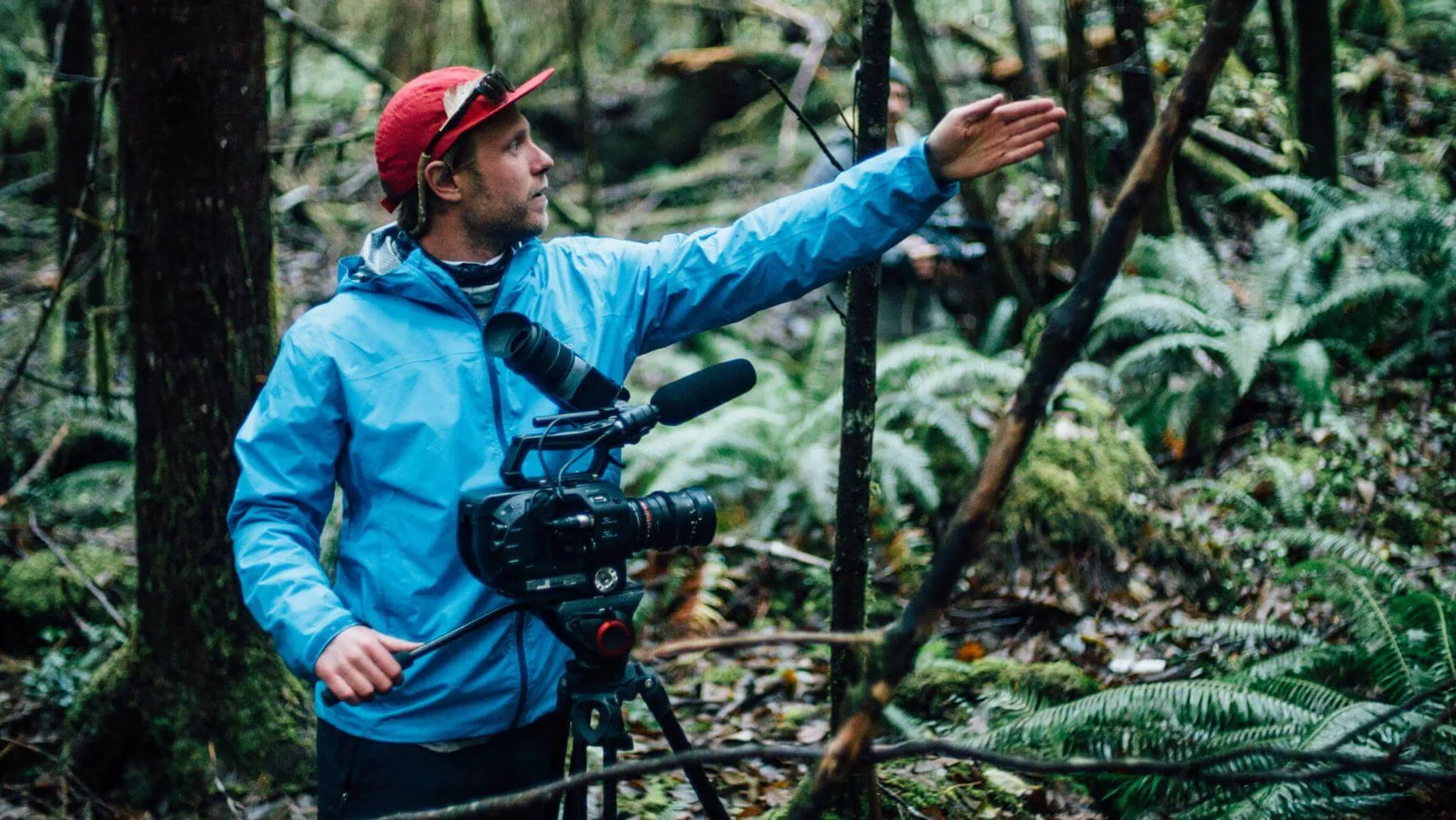 Man holds a film camera in the woods