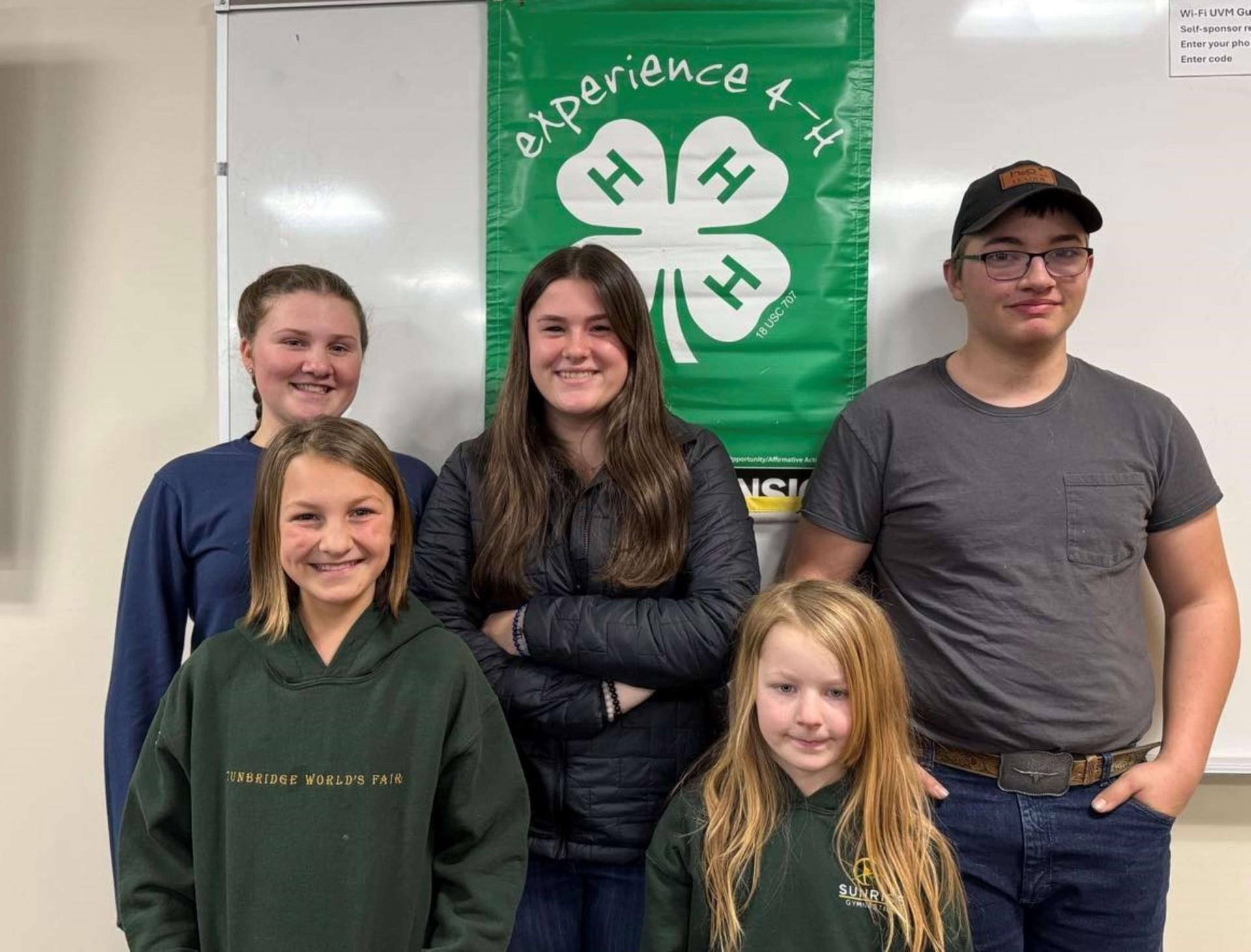 5 4-h teamsters posing in front of a 4-h banner