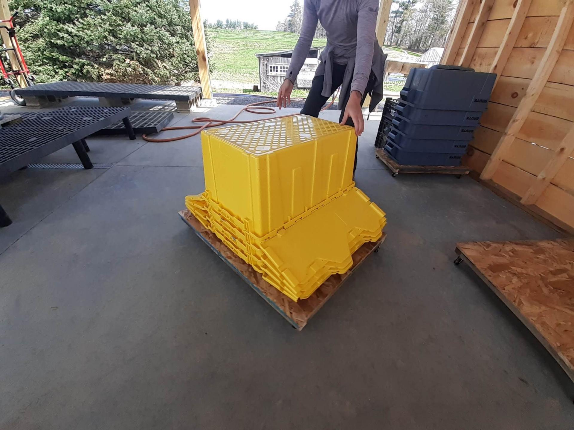 stacked plastic containers on a wooden pallet