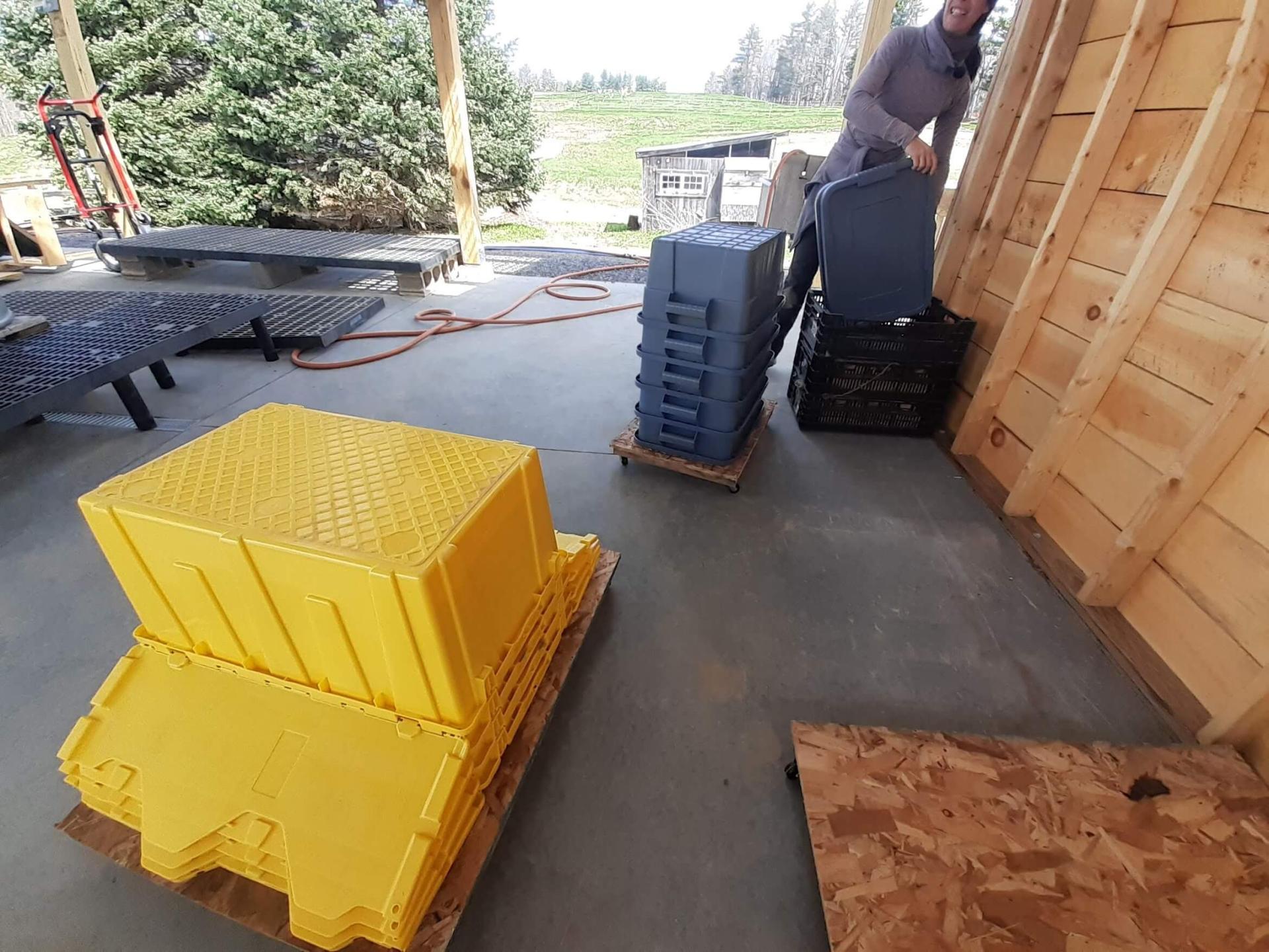 stacked plastic bins on wooden pallets