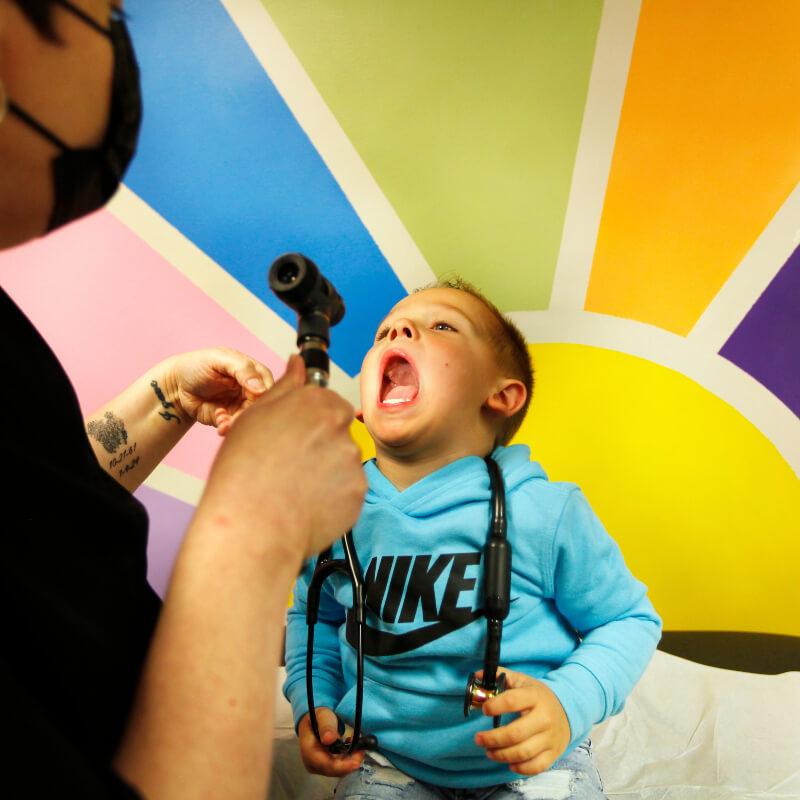 doctor looking into child patient's mouth