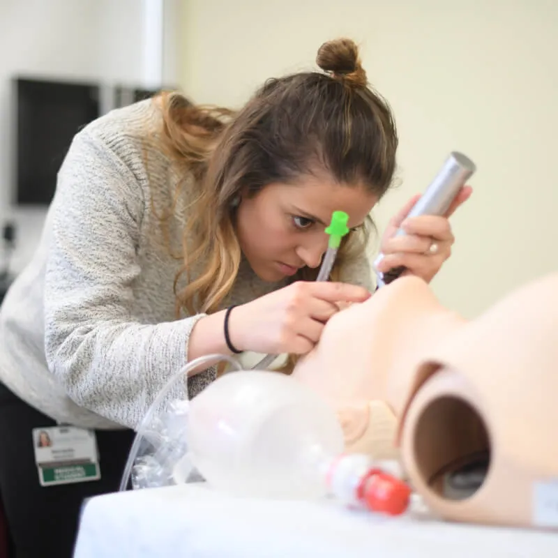 person using tools to intubate a prosthetic patient
