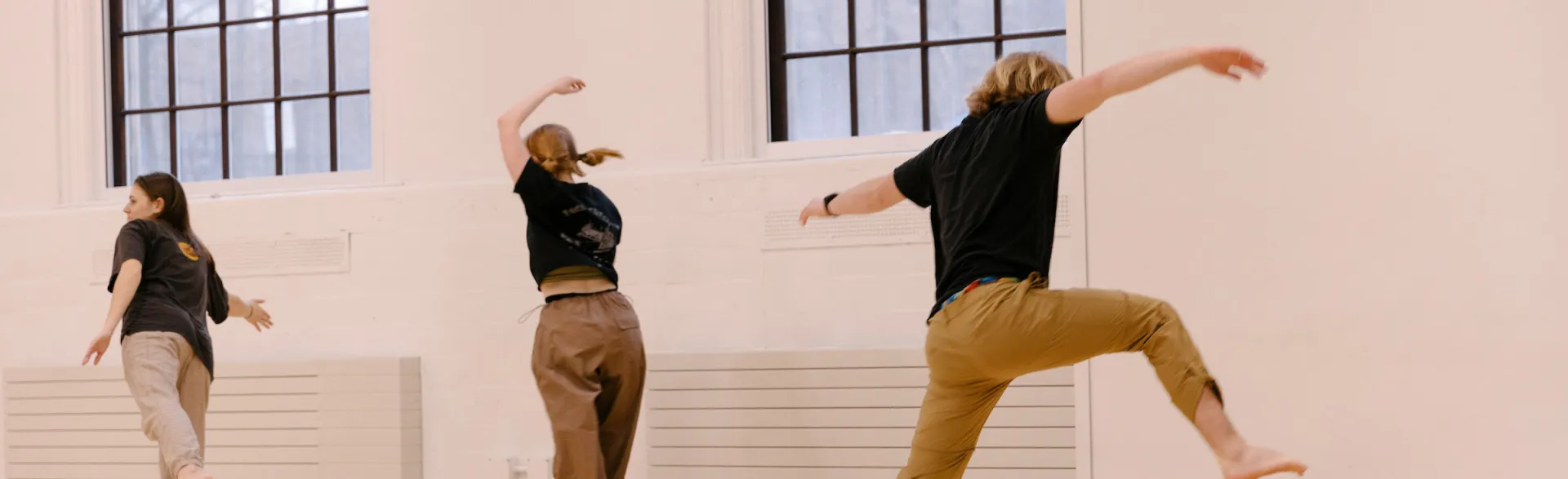 Three people practicing dancing  