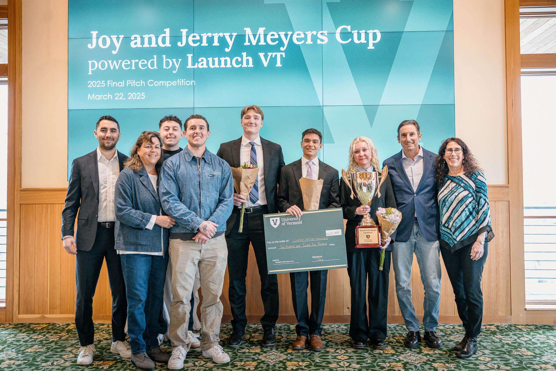 The Meyers Family and the winners of the Meyers Cup hold the check and trophy