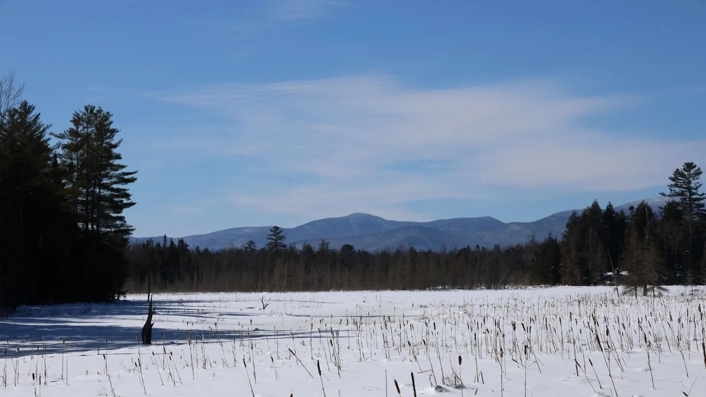 View of frozen Joe's Pond with mountains in the distance