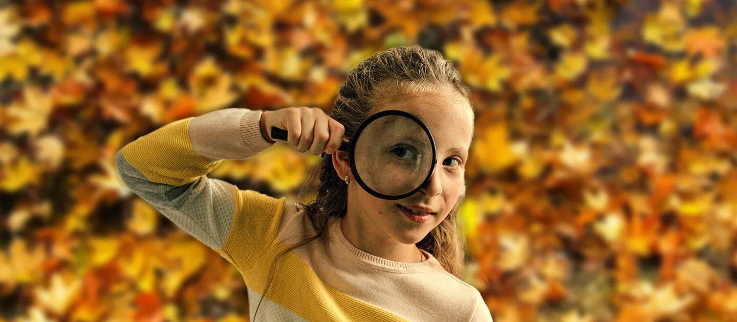 young girl staring through a magnifying glass