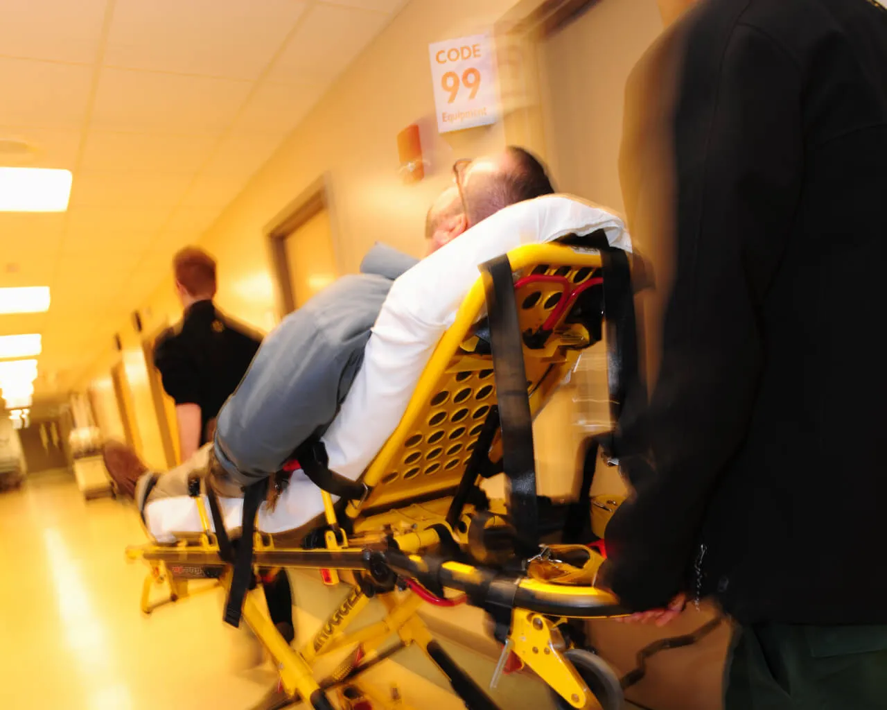 medics wheel a person on stretcher to ED