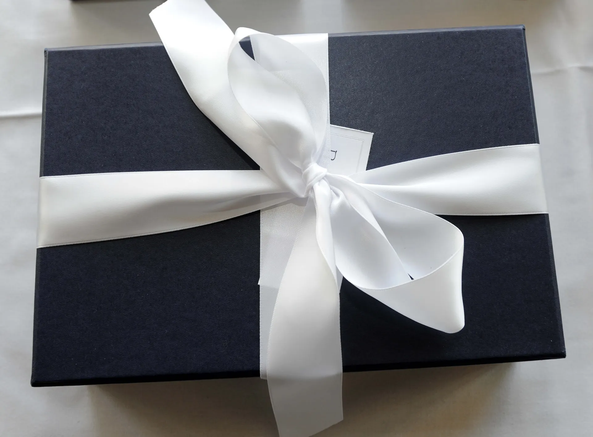 Dark blue box wrapped with a white ribbon 