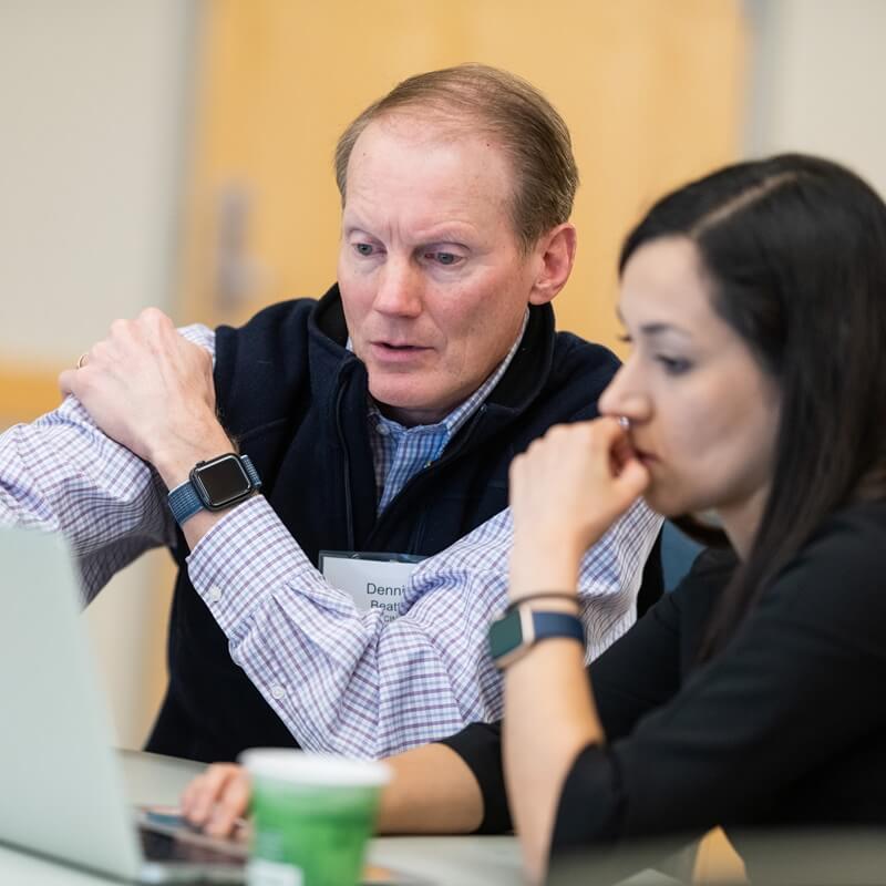 two people work together at a computer