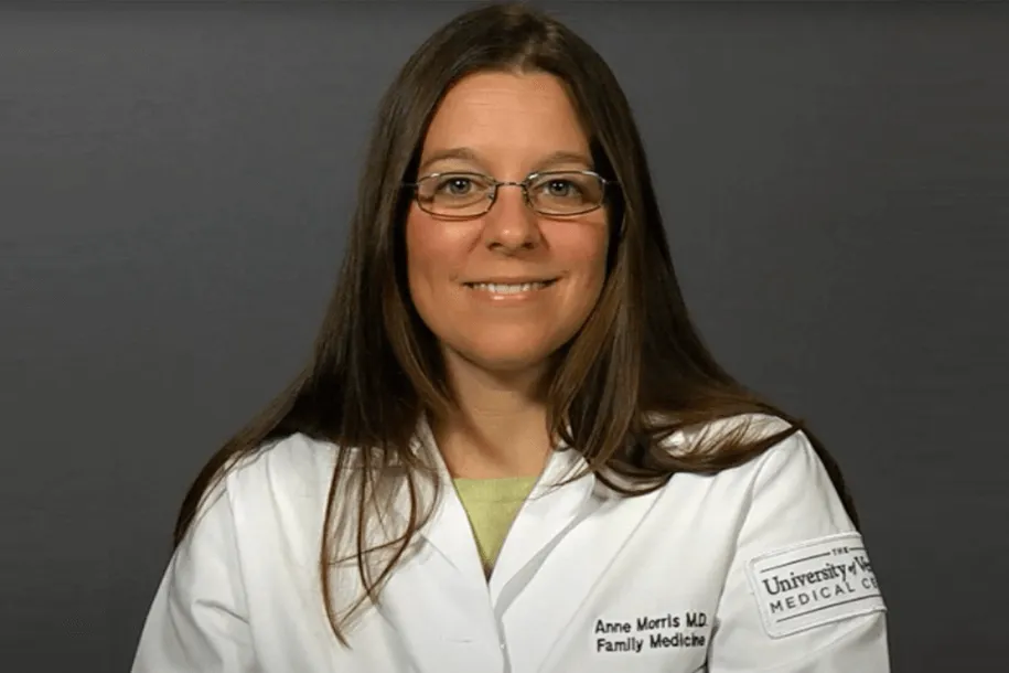 a woman in a white coat smiling