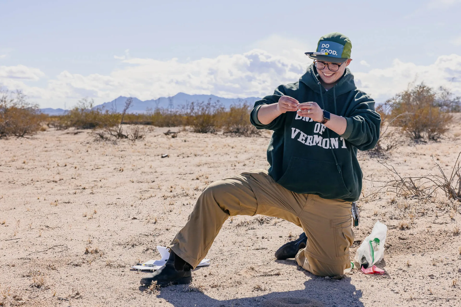 Sof Antello kneels in the California desert