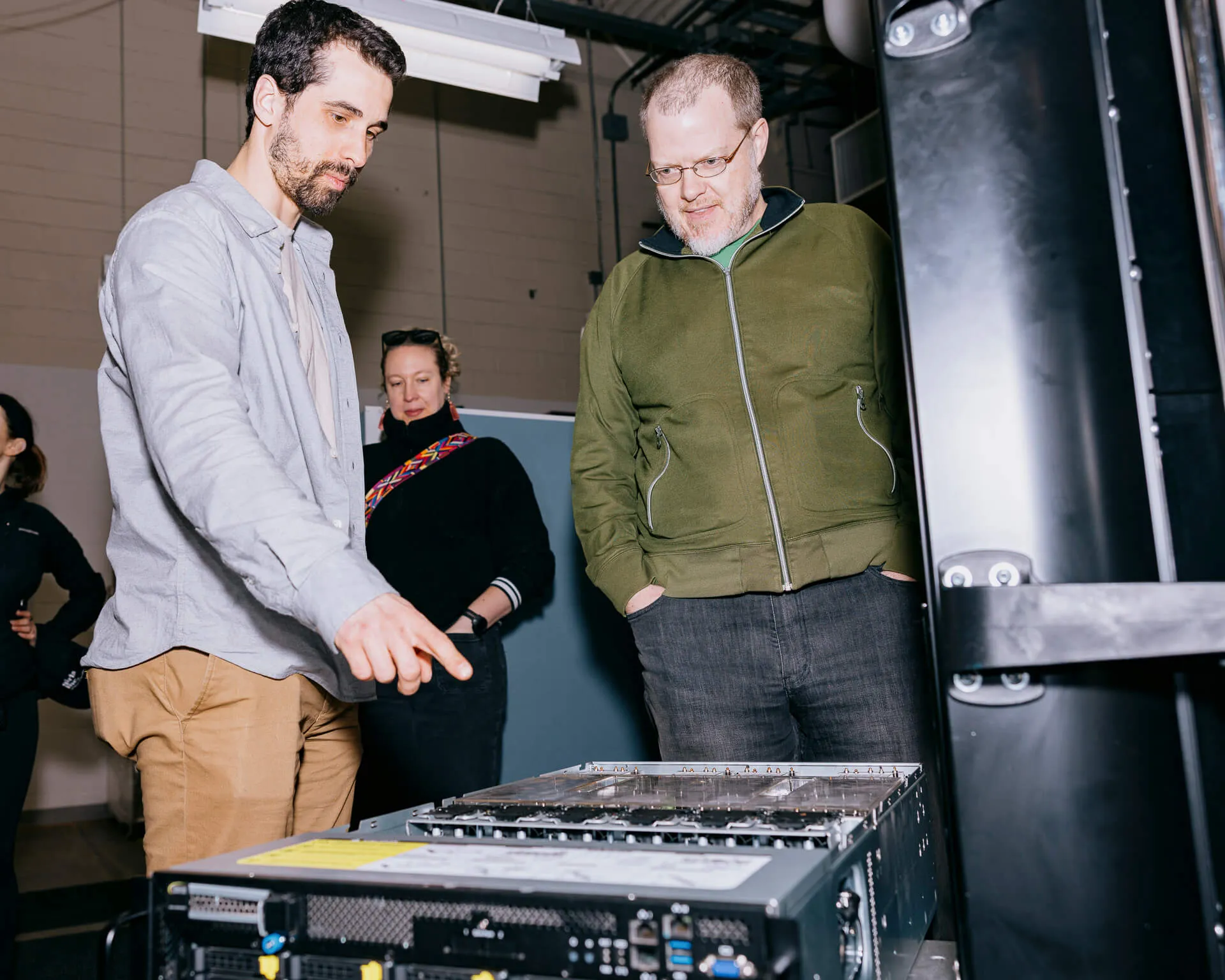 Two people examine a computer server