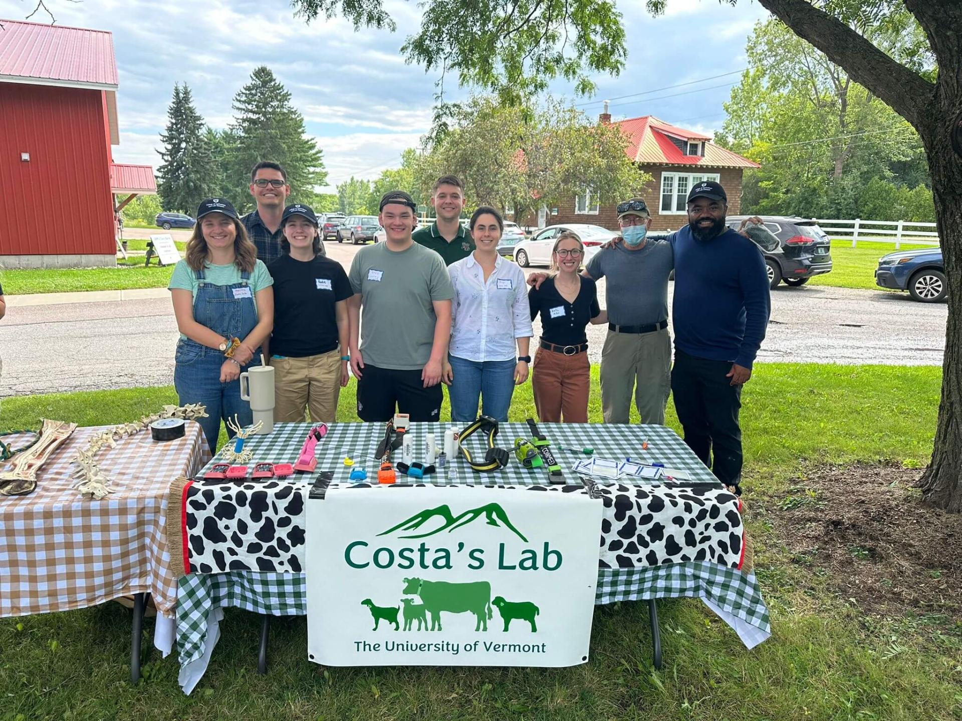 A group of students who work together in the Costa Lab with a table presentation