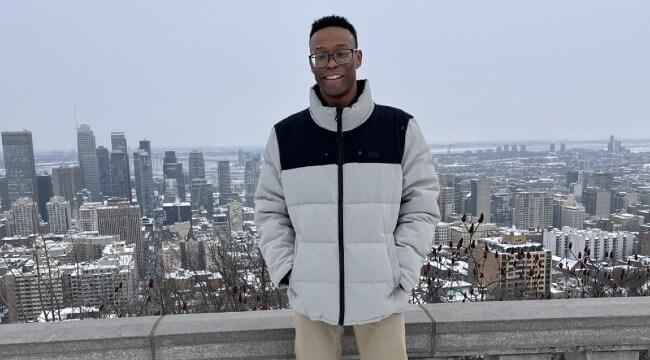 A student standing in front of city skyline