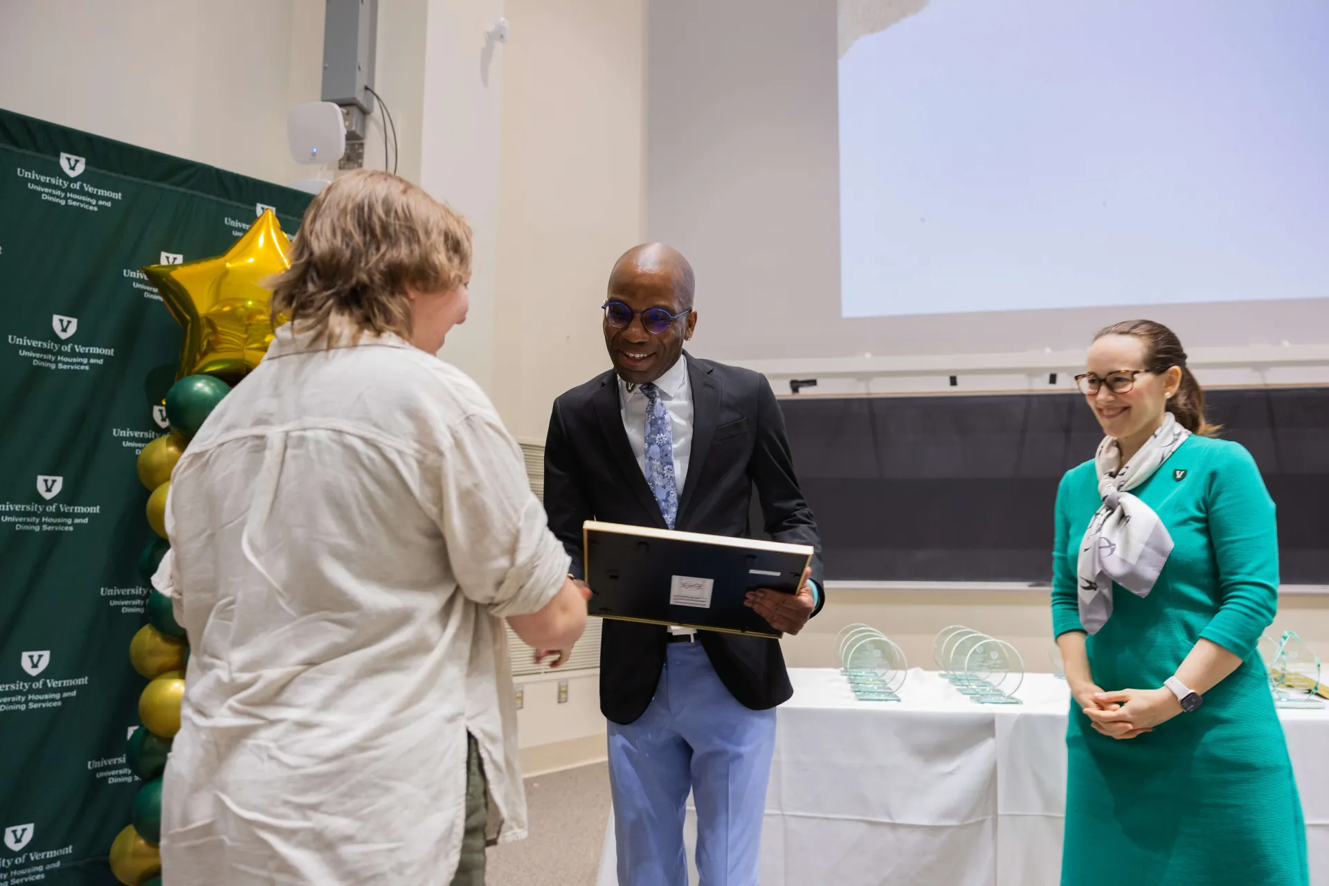 Staff receiving plaque award from head of department  