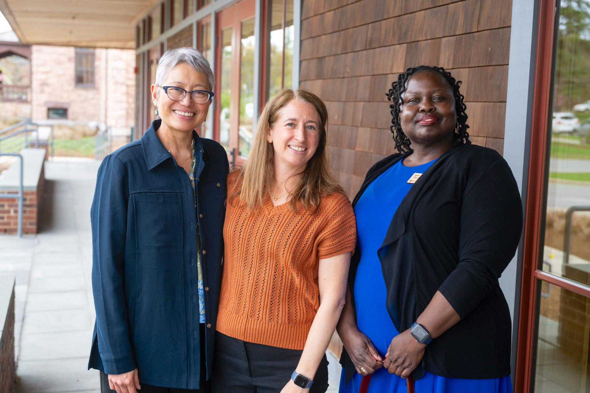 Cynthia Reyes, Kathleen Brinegar, and Jane Okech together outside the Silver Pavilion of the UVM Alumni House.