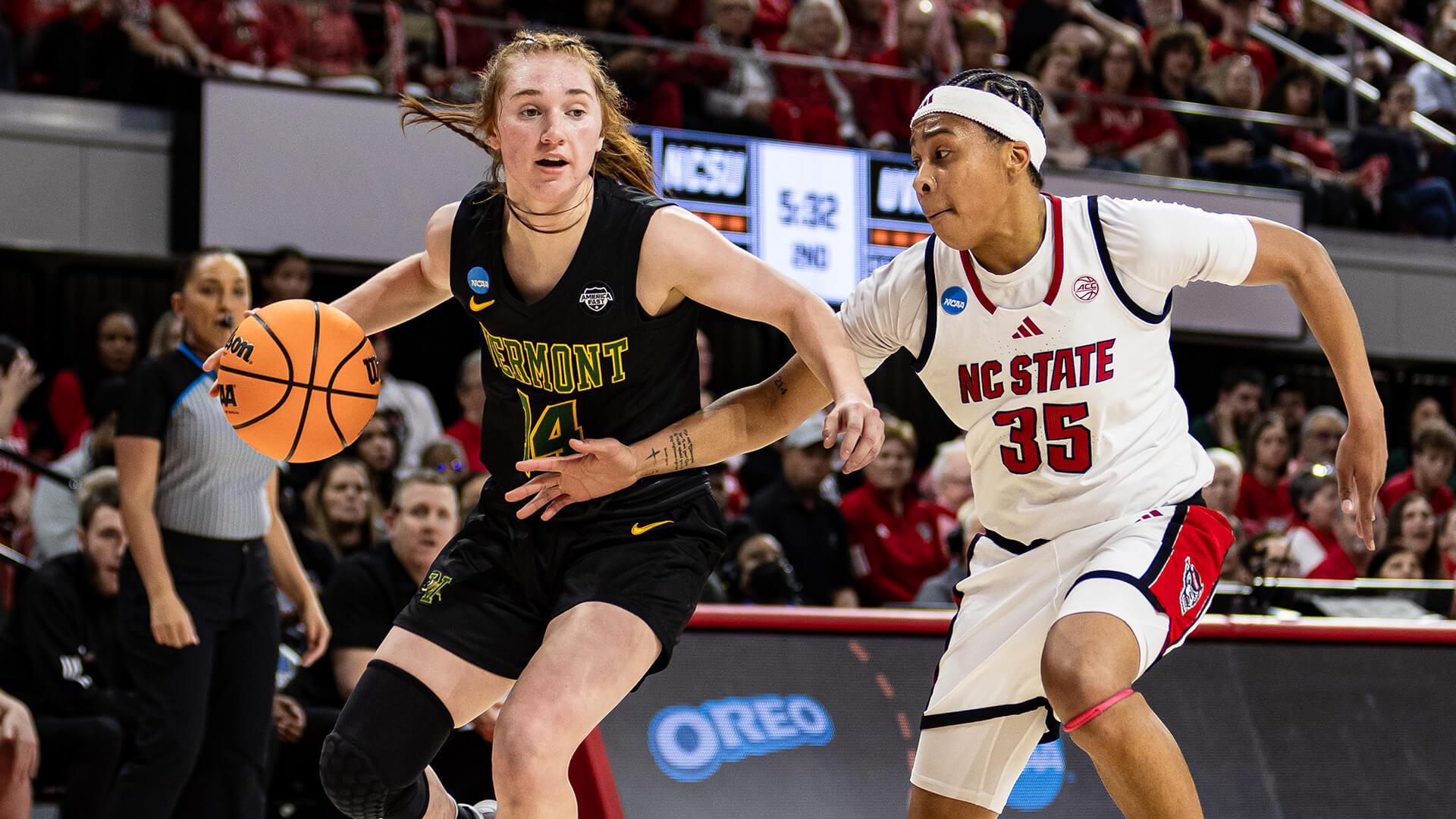 two women compete for a basketball on a courtyard