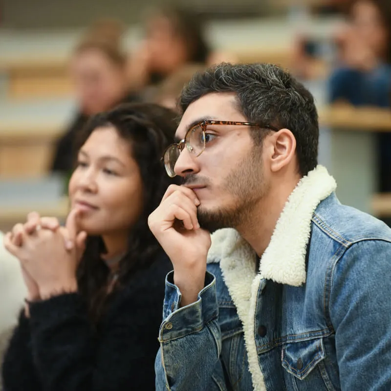 Two people listening to a speaker