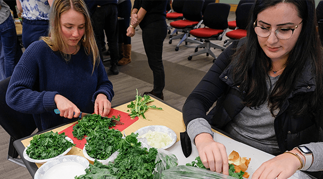 people at a table chopping vegetables