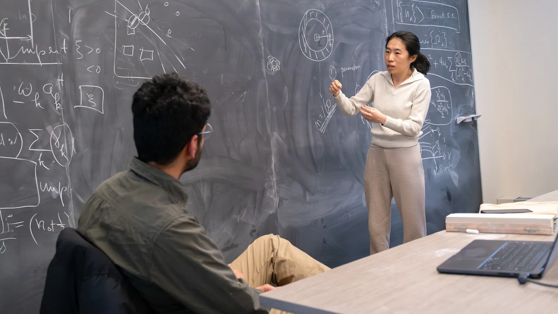 Physics assistant professor Haicen Yue discusses a research publication with her graduate students