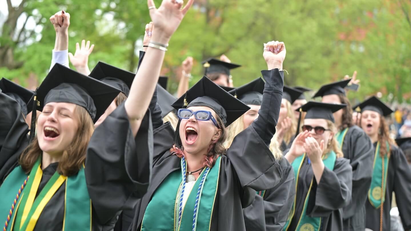 graduates in caps and gowns cheering