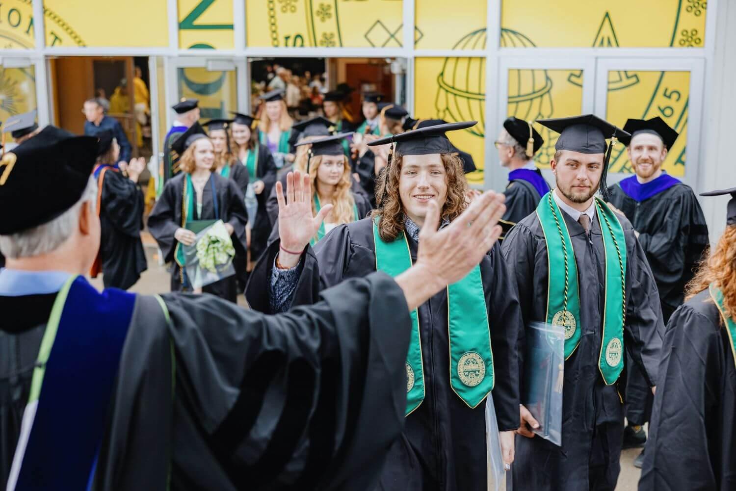 RSENR students in the recessional getting ready to high five a faculty member