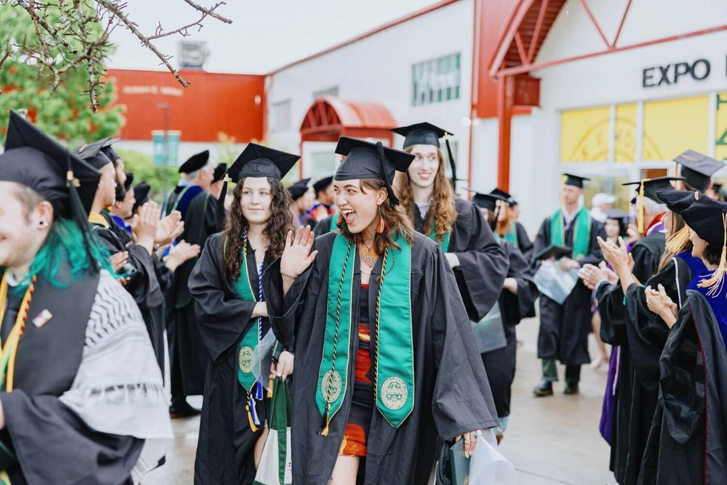 RSENR students in the recessional waving at faculty cheering them on