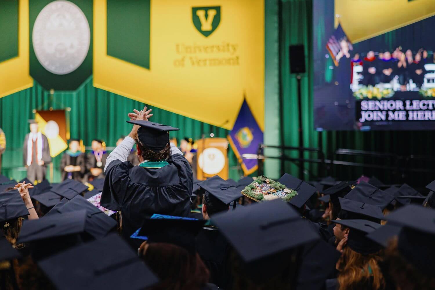 A student standing and clapping during the RSENR commencement ceremony