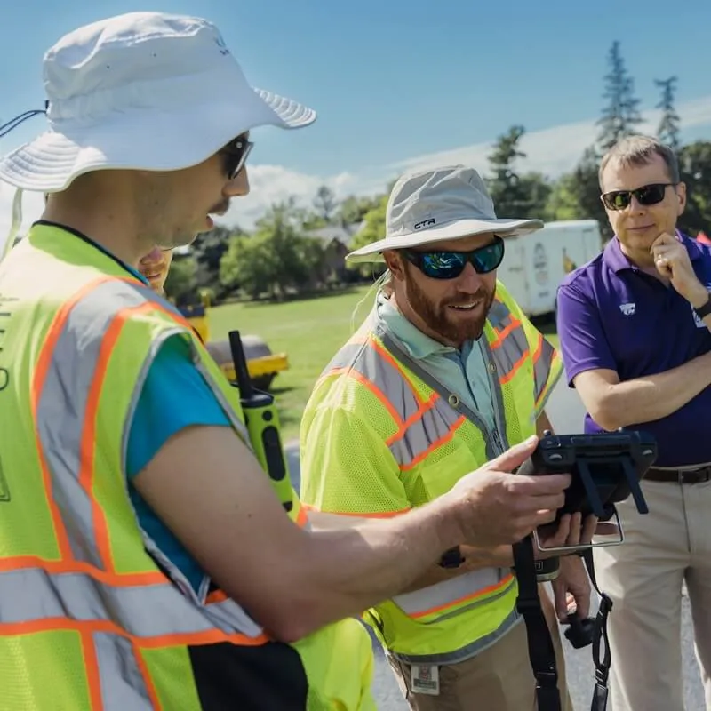 A spatial analysis lab staff person with partners conducting a drone training