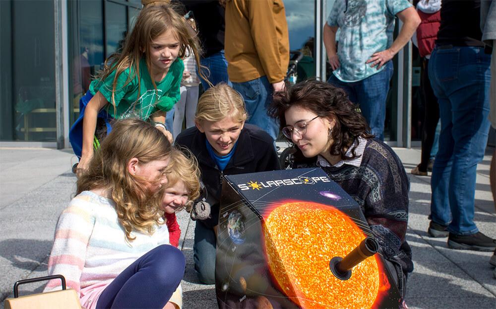 Sarah Phillips shares solar eclipse science with young astronomers during an educational program the UVM Physics Society hosted at ECHO, Leahy Center for Lake Champlain.