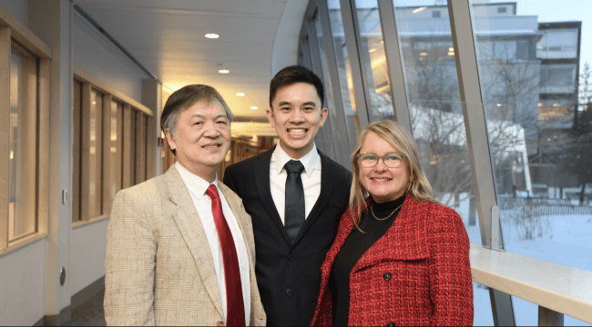Three people standing together smiling inside 