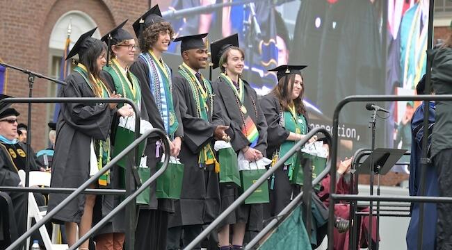 a line of student awardees in regalia