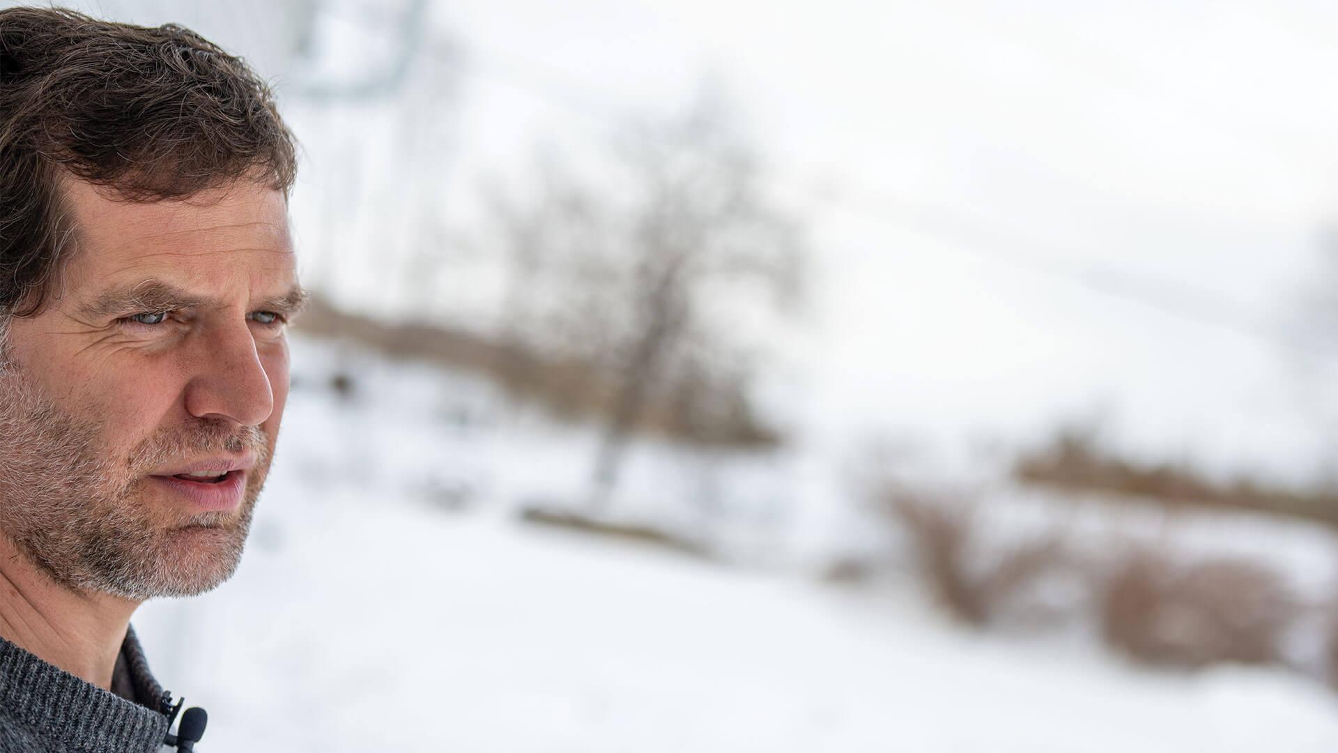 a person looking off camera in a wintery background