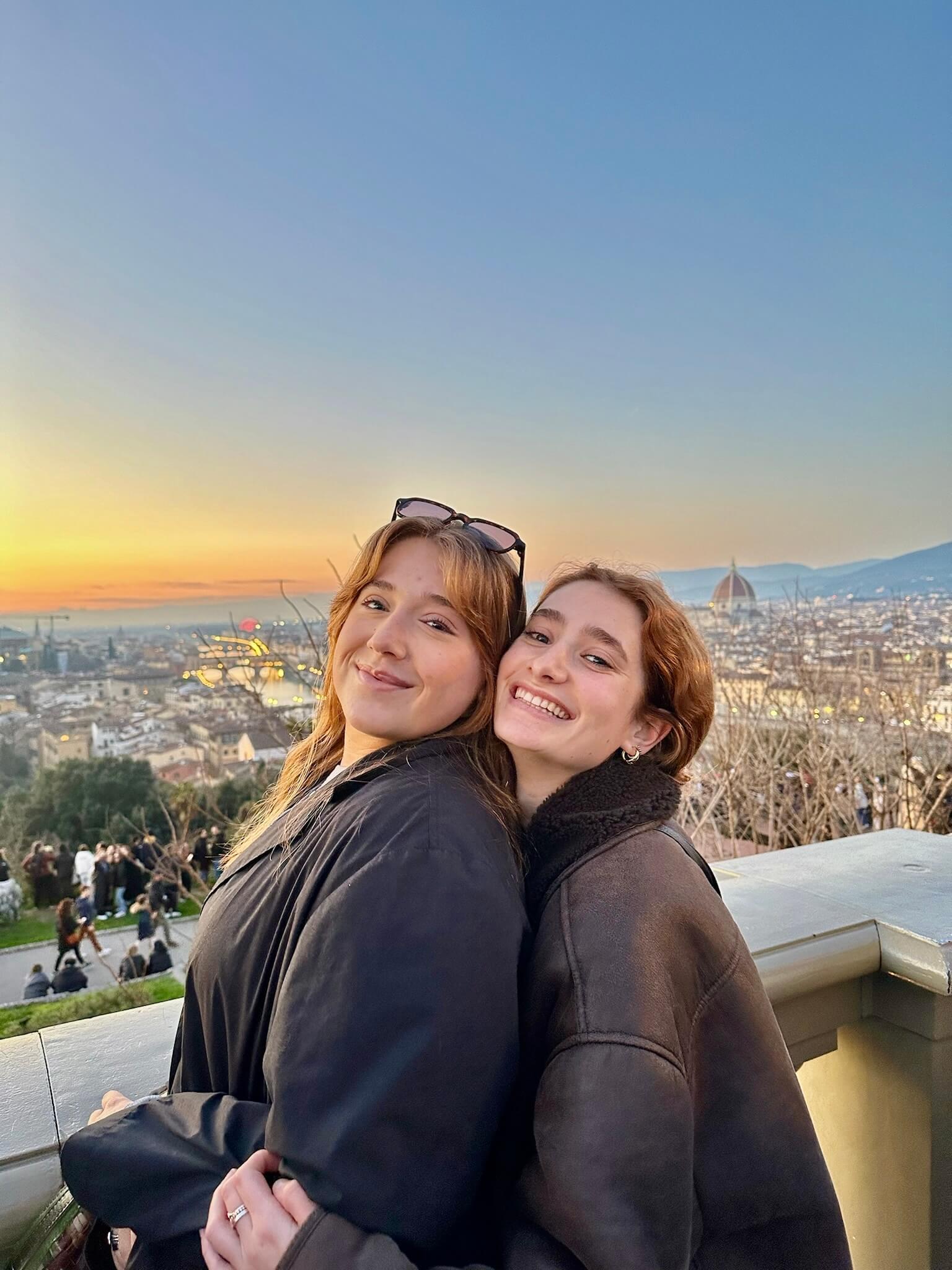 Chloe and a friend in Florence, Italy, with the city skyline in the background, at sunset.