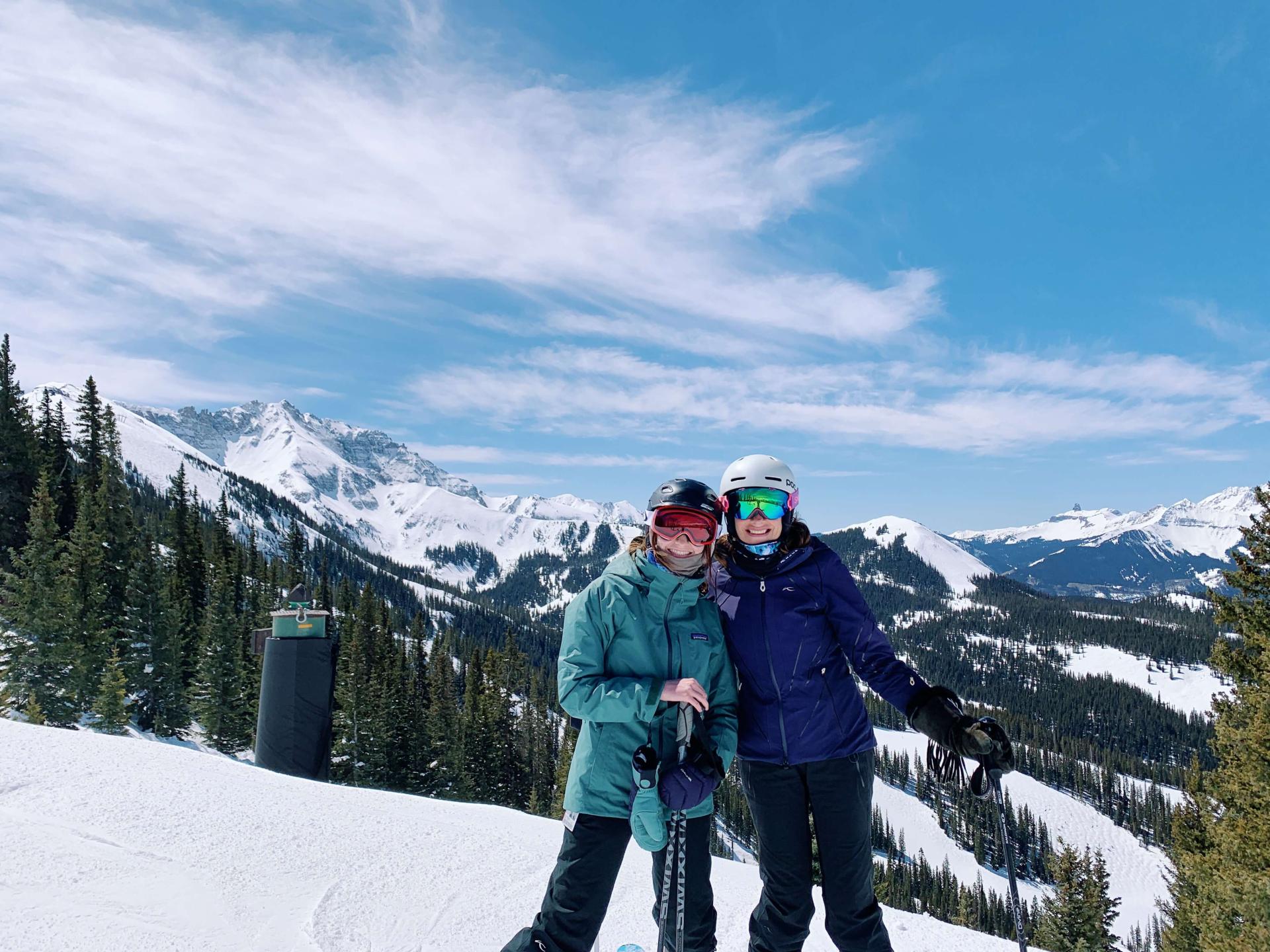 Chloe and a friend wearing ski gear on a ski mountain.