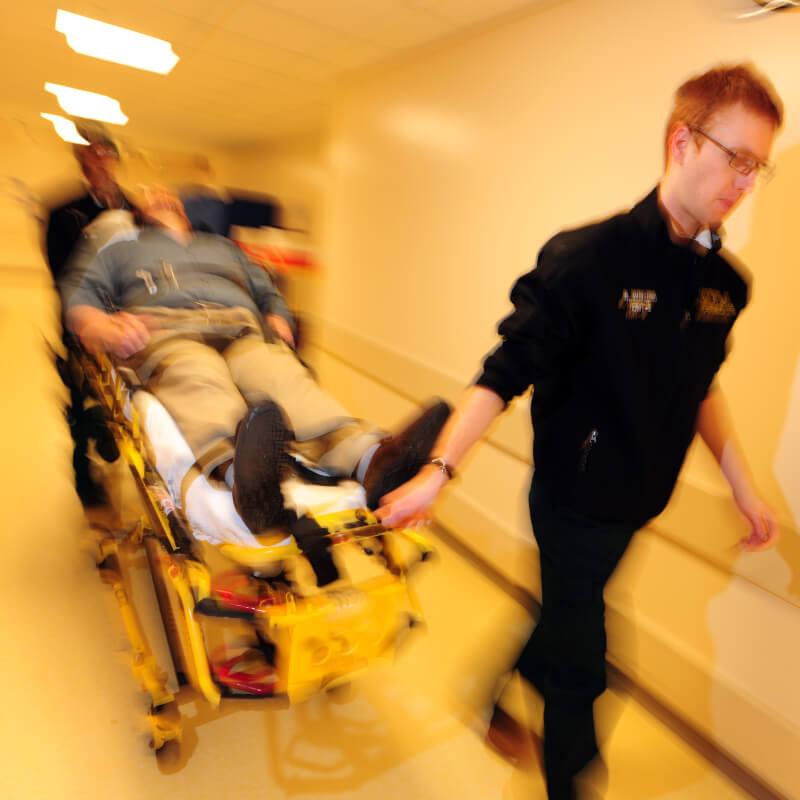 medical responder pulling a patient on a gurney