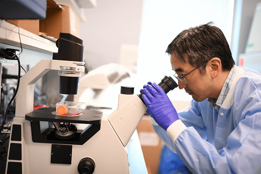 a man at a microscope in a lab