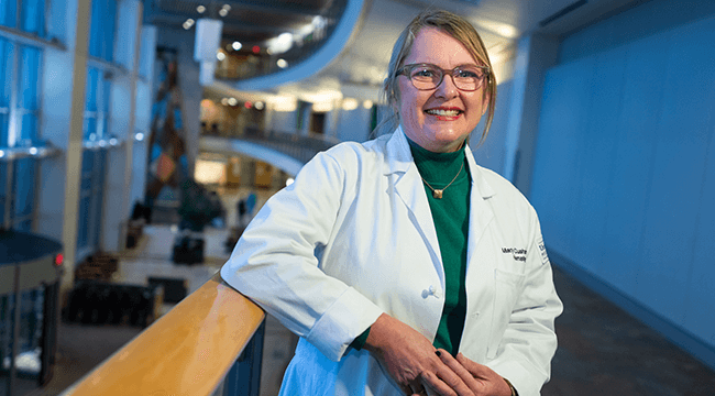 a woman in a white coat smiling