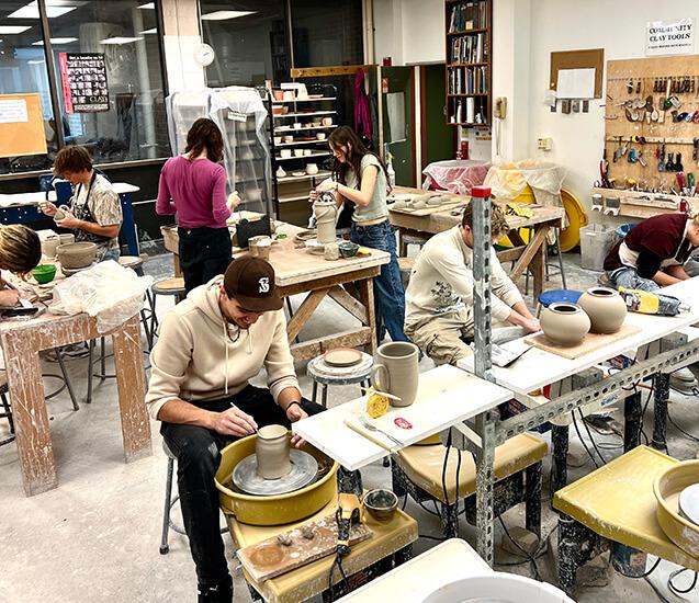 Students working on pottery projects in the ceramics studio