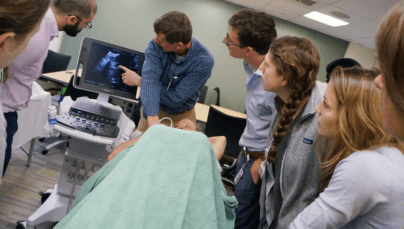 Medical tudents gather around a patient