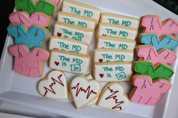 Platter of frosted cookies in the shape of hearts, nametags, and scrub shirts.