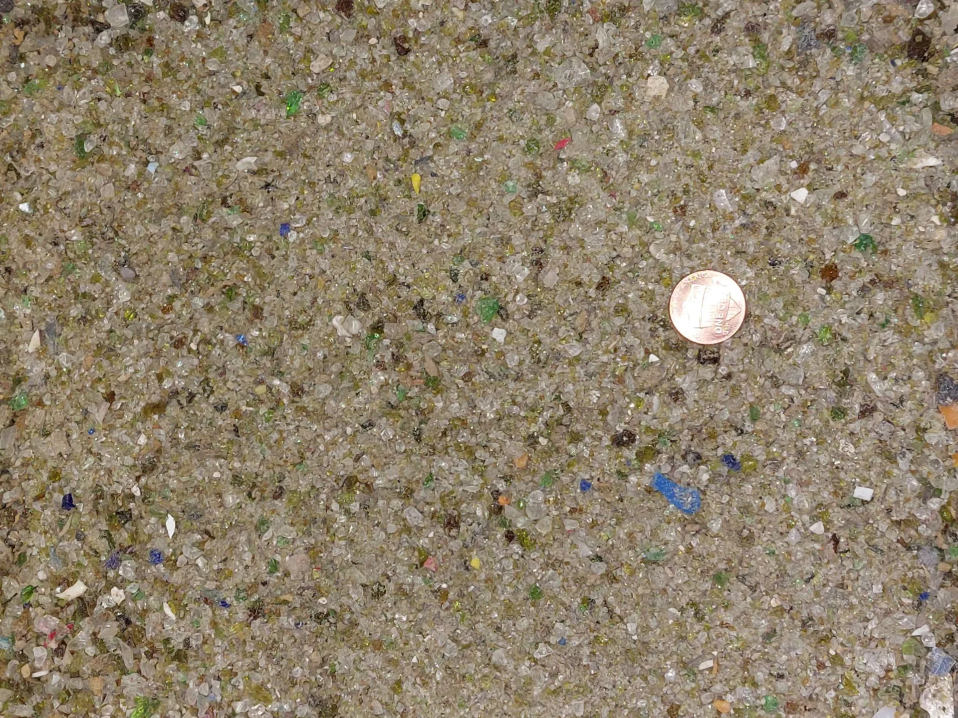 Small pieces of glass with a penny for scale. 