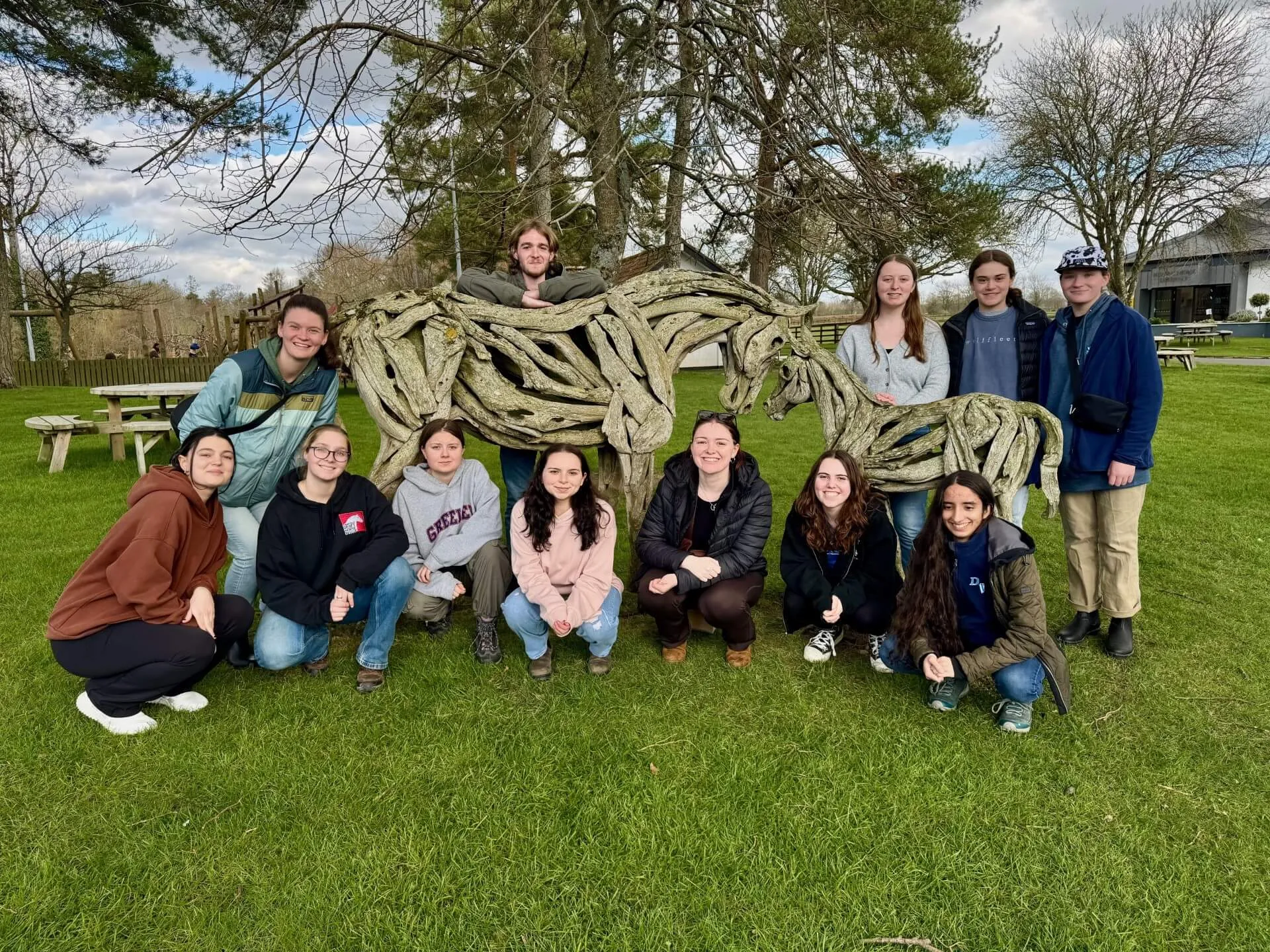 Students gathered around a horse sculpture