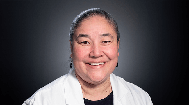 a woman in a white coat smiling