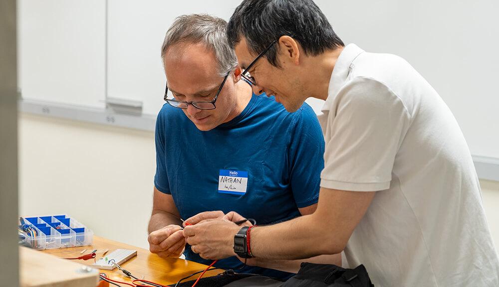 Electrical Engineering Professor Tian Zia helps Hunt Middle School Design and Technology Teacher Nathan Caswell with his circuit project.