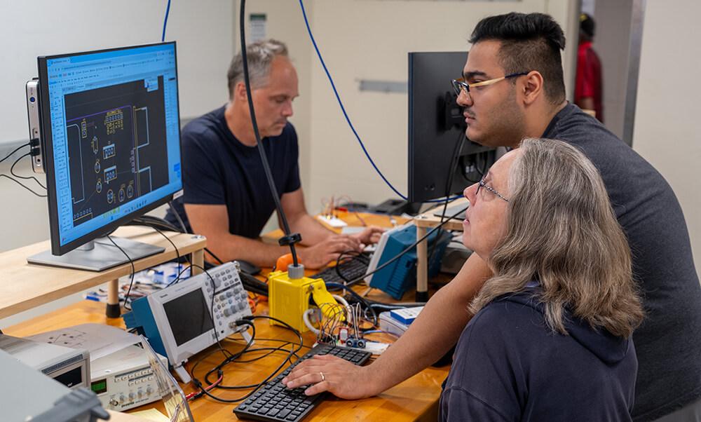 Electrical Engineering PhD student Soheyl Faghir Hagh assists Cavendish Town Elementary School teacher Jennifer Harper as she navigates electronic design software